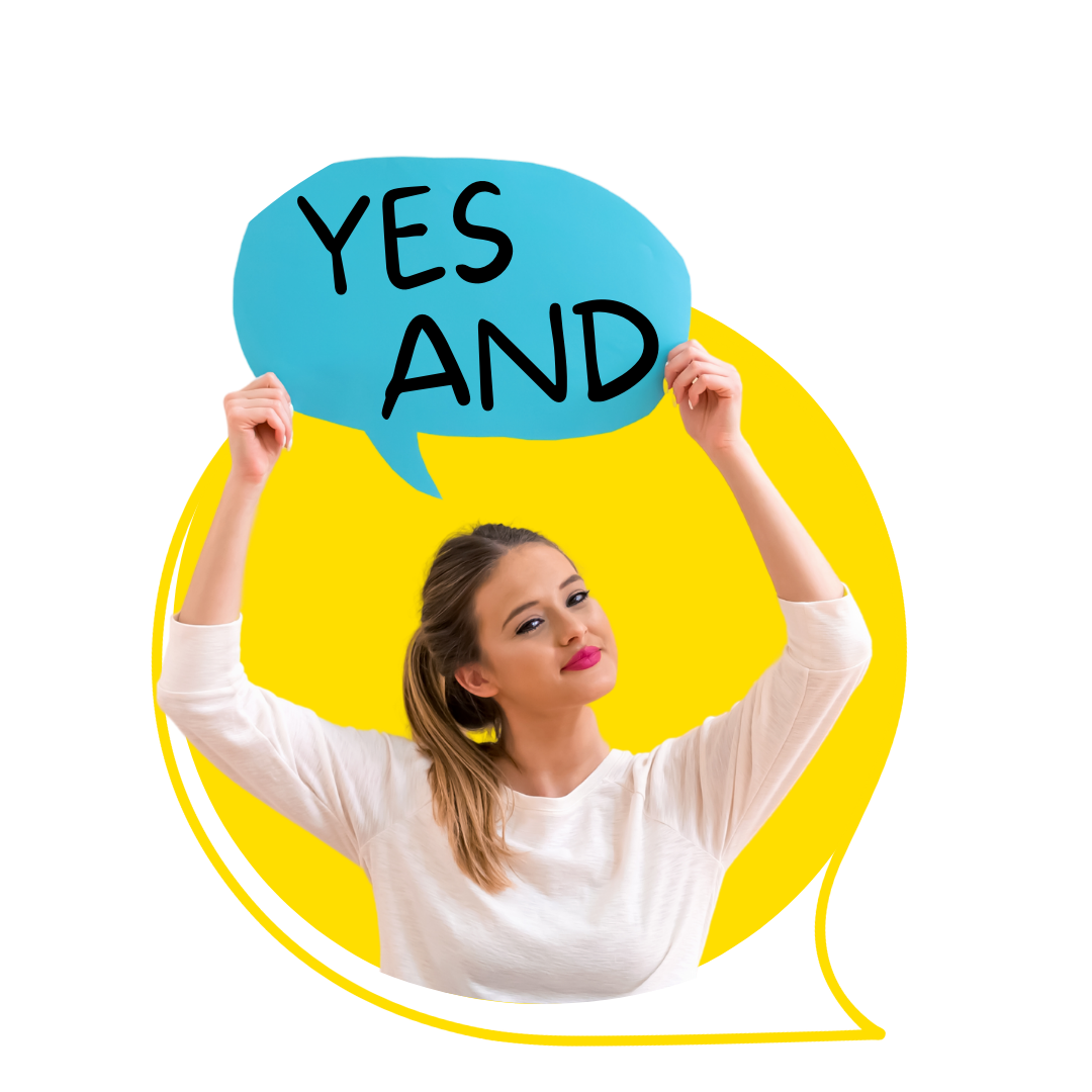 A woman holds up a speech bubble that says "Yes And," which a fundamental of improv comedy.